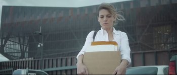 Movie still from “Upstream Color” (2013), directed by Shane Carruth – A woman holding an open box of papers; Medium shot, Low angle
