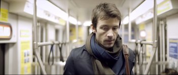 Movie still from “Upstream Color” (2013), directed by Shane Carruth – A man in a jacket and scarf on a train; Close Up shot, Low angle