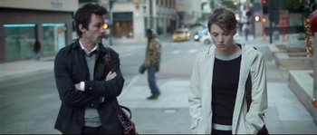 Movie still from “Upstream Color” (2013), directed by Shane Carruth – A man and a woman standing next to each other on the sidewalk; Medium shot, Over the shoulder angle