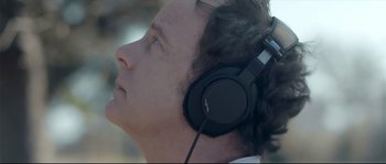 Movie still from “Upstream Color” (2013), directed by Shane Carruth – A person wearing a pair of headphones; Close Up shot, Low angle