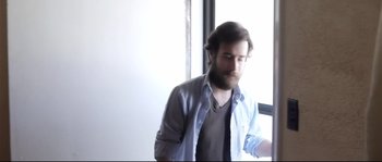 Movie still from “Upstream Color” (2013), directed by Shane Carruth – A man with a beard wearing a blue shirt; Medium shot, Low angle