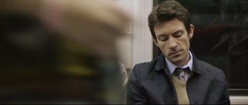 Movie still from “Upstream Color” (2013), directed by Shane Carruth – A person wearing a suit and tie; Close Up shot, Over the shoulder angle
