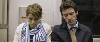 Movie still from “Upstream Color” (2013), directed by Shane Carruth – A man and a woman sitting next to each other on a train; Medium shot, Over the shoulder angle