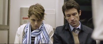 Movie still from “Upstream Color” (2013), directed by Shane Carruth – A man and a woman sitting next to each other on a train; Medium shot, Over the shoulder angle