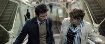 Movie still from “Upstream Color” (2013), directed by Shane Carruth – A man and a woman walking down a train platform; Medium shot, Over the shoulder angle