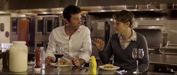 Movie still from “Upstream Color” (2013), directed by Shane Carruth – A man and a woman sitting at a table with plates of food; Medium shot, Over the shoulder angle