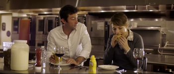 Movie still from “Upstream Color” (2013), directed by Shane Carruth – A man and a woman sitting at a table eating food; Medium shot, Over the shoulder angle
