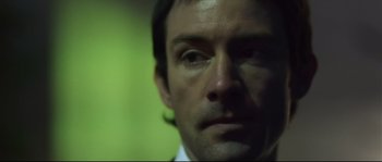 Movie still from “Upstream Color” (2013), directed by Shane Carruth – A man's face in front of a green wall; Close Up shot, Low angle