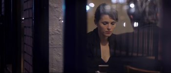 Movie still from “Upstream Color” (2013), directed by Shane Carruth – A woman sitting at a table looking at her cell phone; Close Up shot, Over the shoulder angle