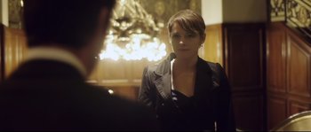 Movie still from “Upstream Color” (2013), directed by Shane Carruth – A woman in a black jacket is looking at the camera; Medium shot, Over the shoulder angle