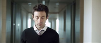 Movie still from “Upstream Color” (2013), directed by Shane Carruth – A man in a black shirt and a white tie; Close Up shot, Low angle