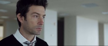Movie still from “Upstream Color” (2013), directed by Shane Carruth – A person wearing a suit and tie; Close Up shot, Over the shoulder angle