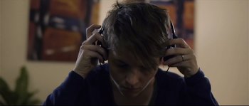 Movie still from “Upstream Color” (2013), directed by Shane Carruth – A person with headphones in a room; Close Up shot, Over the shoulder angle