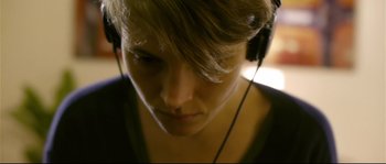 Movie still from “Upstream Color” (2013), directed by Shane Carruth – A person with headphones in their ears; Close Up shot, Low angle