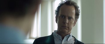 Movie still from “Upstream Color” (2013), directed by Shane Carruth – A person wearing a suit and tie; Close Up shot, Over the shoulder angle