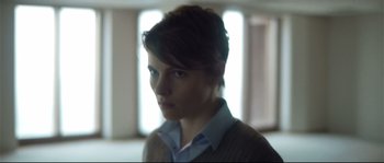 Movie still from “Upstream Color” (2013), directed by Shane Carruth – A woman with short brown hair wearing a sweater; Close Up shot, Low angle