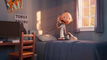 Movie still from “Diary of a Wimpy Kid” (2021), directed by Gino Nichele – A cartoon character is sitting on a bed talking on a phone; Wide shot, High angle