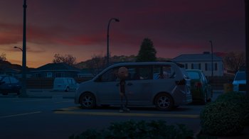 Movie still from “Diary of a Wimpy Kid: Rodrick Rules” (2022), directed by Gino Nichele – A person standing in front of a car on a street; Extreme Wide shot, Low angle
