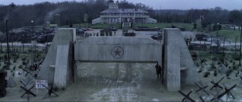 Movie still from “Die Another Day” (2002), directed by Lee Tamahori – A group of men standing next to each other in front of a building; Extreme Wide shot, High angle