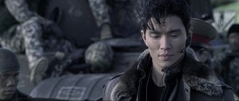 Movie still from “Die Another Day” (2002), directed by Lee Tamahori – A young man in a black jacket is looking down at his face; Close Up shot, Over the shoulder angle