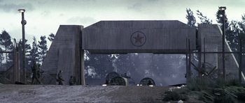Movie still from “Die Another Day” (2002), directed by Lee Tamahori – Two military vehicles driving under an overpass; Extreme Wide shot, Low angle