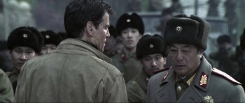 Movie still from “Die Another Day” (2002), directed by Lee Tamahori – A group of men standing next to each other; Close Up shot, Over the shoulder angle