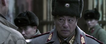 Movie still from “Die Another Day” (2002), directed by Lee Tamahori – A person wearing a military uniform; Close Up shot, Low angle