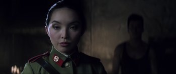 Movie still from “Die Another Day” (2002), directed by Lee Tamahori – A woman in a uniform is looking at the camera; Close Up shot, Over the shoulder angle