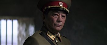 Movie still from “Die Another Day” (2002), directed by Lee Tamahori – A man in a military uniform and a red hat; Close Up shot, Low angle