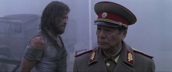 Movie still from “Die Another Day” (2002), directed by Lee Tamahori – A man in a military uniform standing next to another man; Medium shot, Over the shoulder angle
