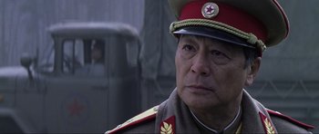 Movie still from “Die Another Day” (2002), directed by Lee Tamahori – An older man in a military uniform looking at the camera; Close Up shot, Low angle