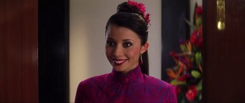 Movie still from “Die Another Day” (2002), directed by Lee Tamahori – A woman in a purple dress with a pink flower in her hair; Close Up shot, Over the shoulder angle