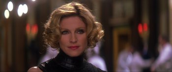 Movie still from “Die Another Day” (2002), directed by Lee Tamahori – A person with blonde hair wearing a black dress; Close Up shot, Low angle