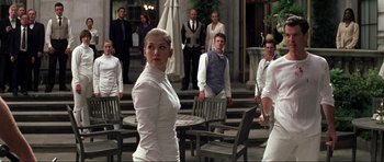 Movie still from “Die Another Day” (2002), directed by Lee Tamahori – A group of people standing around a building; Medium shot, Over the shoulder angle