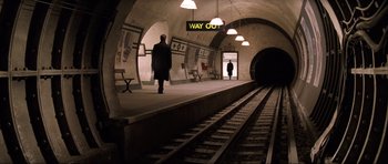 Movie still from “Die Another Day” (2002), directed by Lee Tamahori – A man standing on a train platform next to a train; Extreme Wide shot, High angle