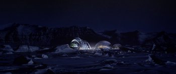 Movie still from “Die Another Day” (2002), directed by Lee Tamahori – A group of buildings lit up at night in the snow; Extreme Wide shot, High angle
