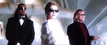 Movie still from “Die Another Day” (2002), directed by Lee Tamahori – A woman wearing sunglasses and a white dress; Medium shot, Low angle