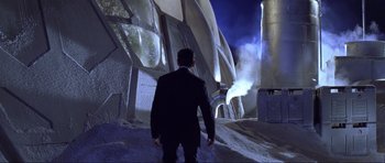 Movie still from “Die Another Day” (2002), directed by Lee Tamahori – A man in a black suit is walking down a street; Extreme Wide shot, Low angle