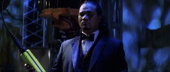 Movie still from “Die Another Day” (2002), directed by Lee Tamahori – A man in a suit and bow tie; Close Up shot, Low angle