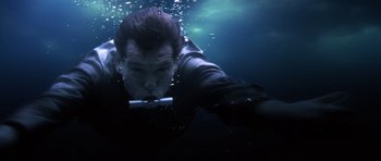 Movie still from “Die Another Day” (2002), directed by Lee Tamahori – A man swimming underwater holding a camera; Close Up shot, Overhead angle