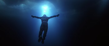 Movie still from “Die Another Day” (2002), directed by Lee Tamahori – A man swimming in a body of water at night; Wide shot, Low angle