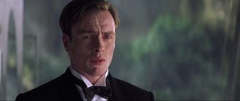 Movie still from “Die Another Day” (2002), directed by Lee Tamahori – A person wearing a suit and bow tie; Close Up shot, Low angle
