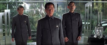 Movie still from “Die Another Day” (2002), directed by Lee Tamahori – A man in a black suit standing next to another man in a black suit; Medium shot, Low angle