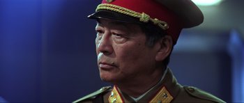Movie still from “Die Another Day” (2002), directed by Lee Tamahori – An older man wearing a military uniform and a hat; Close Up shot, Low angle