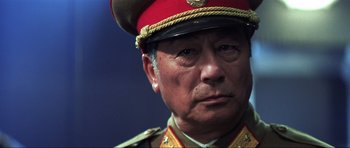 Movie still from “Die Another Day” (2002), directed by Lee Tamahori – An older man wearing a military uniform and a hat; Close Up shot, Low angle