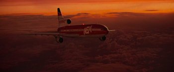 Movie still from “Die Hard 2” (1990), directed by Renny Harlin – An airplane is flying through the sky at sunset; Extreme Wide shot, Low angle