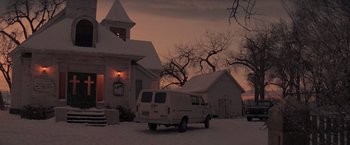 Movie still from “Die Hard 2” (1990), directed by Renny Harlin – A van parked in front of a house on a snowy day; Extreme Wide shot, Low angle