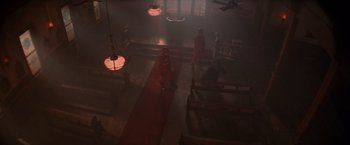 Movie still from “Die Hard 2” (1990), directed by Renny Harlin – A group of people standing inside of a building; Extreme Wide shot, High angle