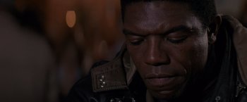 Movie still from “Die Hard 2” (1990), directed by Renny Harlin – A person wearing a leather jacket; Close Up shot, High angle