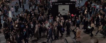 Movie still from “Die Hard 2” (1990), directed by Renny Harlin – A crowd of people walking down a street; Extreme Wide shot, High angle